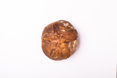 Round loaf of freshly backed sourdough bread on wooden tableの写真素材