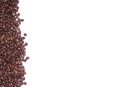 top view of White cup filled with freshly roasted coffee beans isolated on white backgroundの写真素材