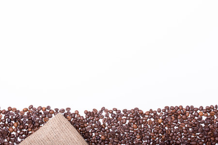 top view of White cup filled with freshly roasted coffee beans isolated on white backgroundの写真素材