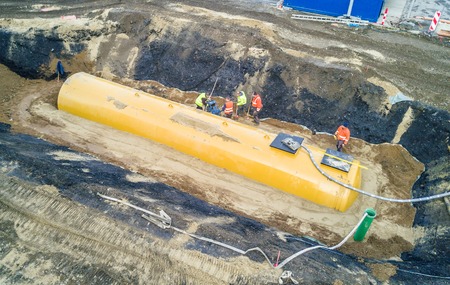 Worker installing a huge fuel tankの写真素材