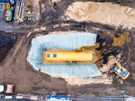 Worker installing a huge fuel tankの写真素材
