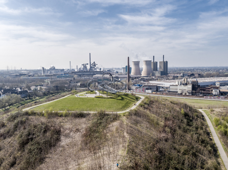 DUISBURG / GERMANY - OCTOBER 06 2016 : Landmark Tiger and Turtle standing on a hill while HKM is producing steel in the background, aerialのeditorial素材