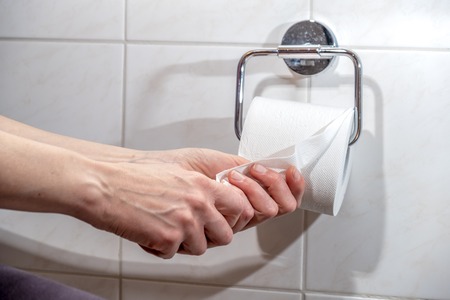 Close-up Of A ladys Hand Using Toilet Paperの写真素材