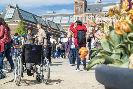 Amsterdam / Netherlands - April 31, 2017 - Wheelchair standing in the middle of the crowd on museumplein in Amsterdamのeditorial素材