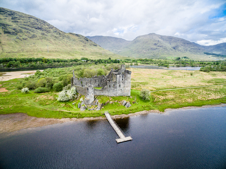 The ruins of historic Kilchurn Castle and jetty on Loch Aweの写真素材
