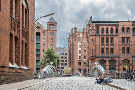 Hamburg / Germany - July 14, 2017: Young folks sitting in the streets of the famous Speicherstadtのeditorial素材