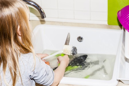 Girl in the kitchen with brush and knife in her handの写真素材