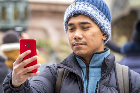 Munich / Germany - February 15 2018: Asian boy taking selfies with her smartphoneのeditorial素材