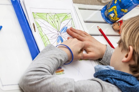 Left handed young boy working on his homeworkの写真素材