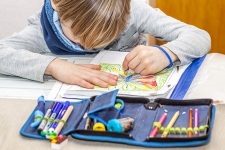 Left handed young boy working on his homeworkの写真素材