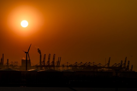 Large harbor cranes loading container ships in the port of Rotterdamの写真素材