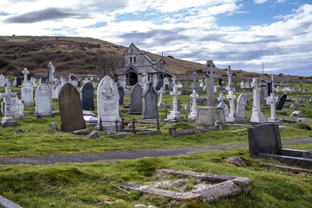 Llandudno / Wales, UK - April 22 2018 : Dramtic graves standing at St Tudnos church and cemetery on the Great Orme at Llandudno, Wales, UKのeditorial素材