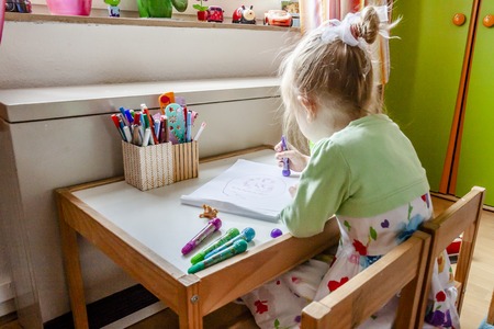 Cute little girl painting in her room at homeの写真素材