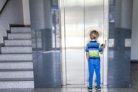 Little boy is calling the elevatorの写真素材
