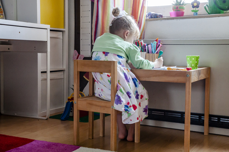 Cute little girl painting in her room at homeの写真素材