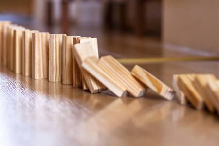 Wooden blocks standing on wooden floor - ready to tiltの写真素材