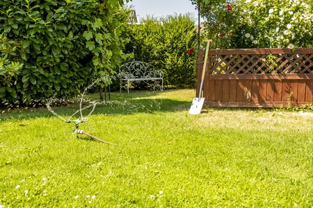 Sprinkler of automatic watering system working in the hot summerの写真素材