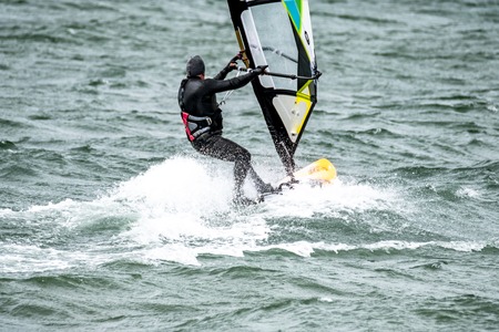 Man windsurfing close to the town of Caernarfon in Wales - United Kingdom.