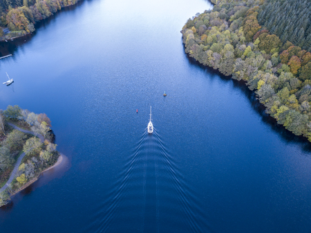 Flying through the Great Glen above Loch Oich towards Loch Ness behind a white motor yacht in the...