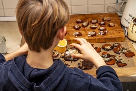 Young boy decorating cookies in the kitchen