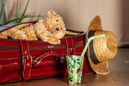 Travel concept of Teddy bear and red vintage suitcaseの写真素材