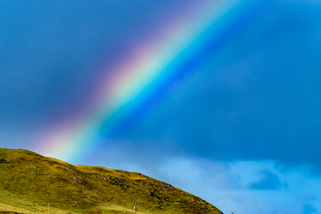Close up of beautiful natural rainbow above a hillの写真素材