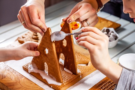 Familiy building a sweet ginger bread houseの写真素材