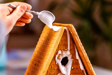 Familiy building a sweet ginger bread houseの写真素材