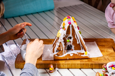 Familiy building a sweet ginger bread houseの写真素材