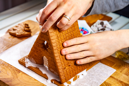 Familiy building a sweet ginger bread houseの写真素材