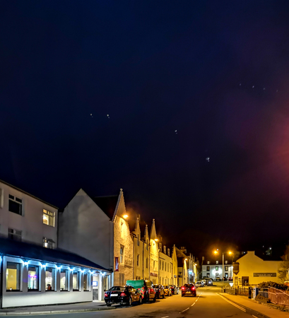 Portree, Isle of Skye / Scotland - October 25 2019 : The main street in Portree is enlightened...