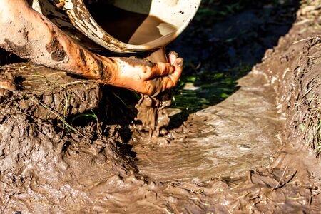 Boy working and playing in the mud.