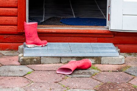 Wellies lying in the entrance of the wooden houseの写真素材