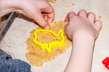 Little brother and sister baking cookies in the kitchen at home.