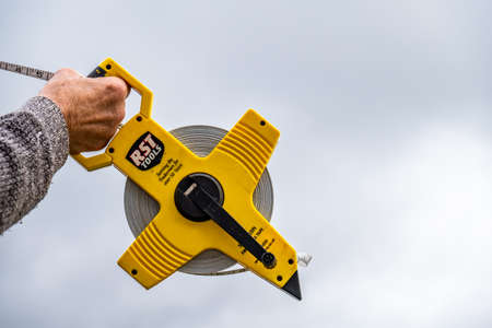 Donegal / Ireland - May 15 2020 : Construction worker using his long surveyor tape meterのeditorial素材