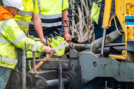 Donegal / Ireland - June 12 2020 : Builder trying to repair Asphalting paver machine during the reopening after Covid 19 lockdownのeditorial素材
