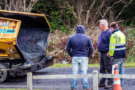 Donegal / Ireland - June 12 2020 : Builder trying to repair Asphalting paver machine during the...