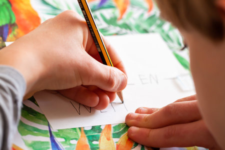 Kid writing on paper - Homework during the Covid 19 pandemicの写真素材