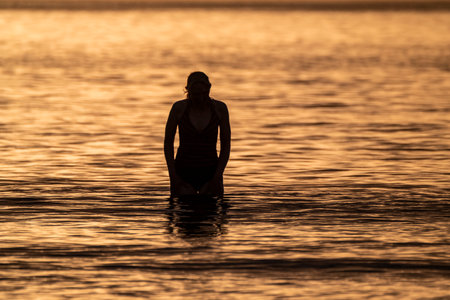 Silhouette of female swimmer going into the Atlantic ocean in Irelandの写真素材