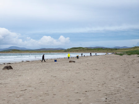 20 man are competing in a fishing competition on the beach.の写真素材