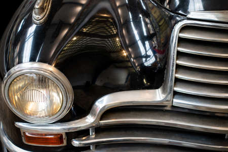 Detail of the front headlight of an old black carの写真素材