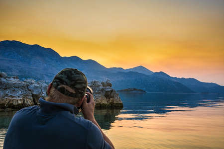 Wildlife photographer during sunset on kayak at Skadar Lake.の写真素材