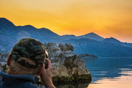 Wildlife photographer during sunset on kayak at Skadar Lake.の写真素材