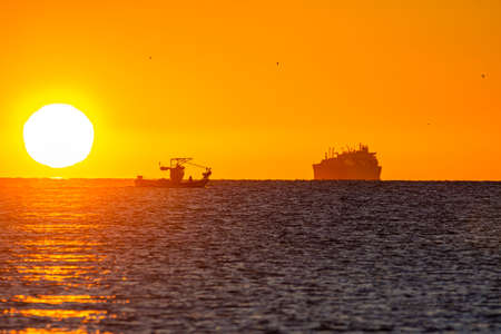 Boats passing through the Strait of Gibraltar during sunrise, Spain.