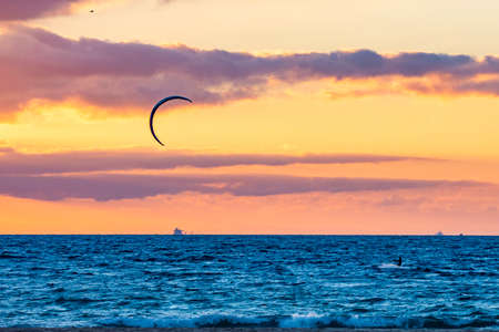 Man that practice kite surf is recovering the comet in a sunset in tarifa.