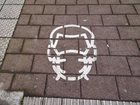 White protective face mask symbol on walking street in Germany city during lockdown by epidemic of COVID-19. Obligation to cover the mouth and nose in the city center.のeditorial素材