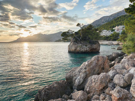 Punta Rata Beach in Brela. Stone symbol of Brela and sunset. Beautiful sea landscape.