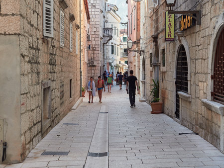 Makarska, Dalmatia, Croatia - July 20, 2021: Narrow streets of the old Croatian town with historic buildings. Walking tourists.のeditorial素材