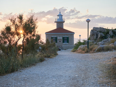 Makarska, Dalmatia, Croatia - July 20, 2021: Sveti Petar Lighthouse in the rays of the setting sun.のeditorial素材
