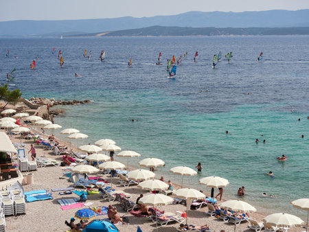 Bol, Croatia, July 25, 2021: Windsurfers surfing on the sea at Zlatni Rat beach. Symbol of the Adriatic Sea on the island of Brac.のeditorial素材